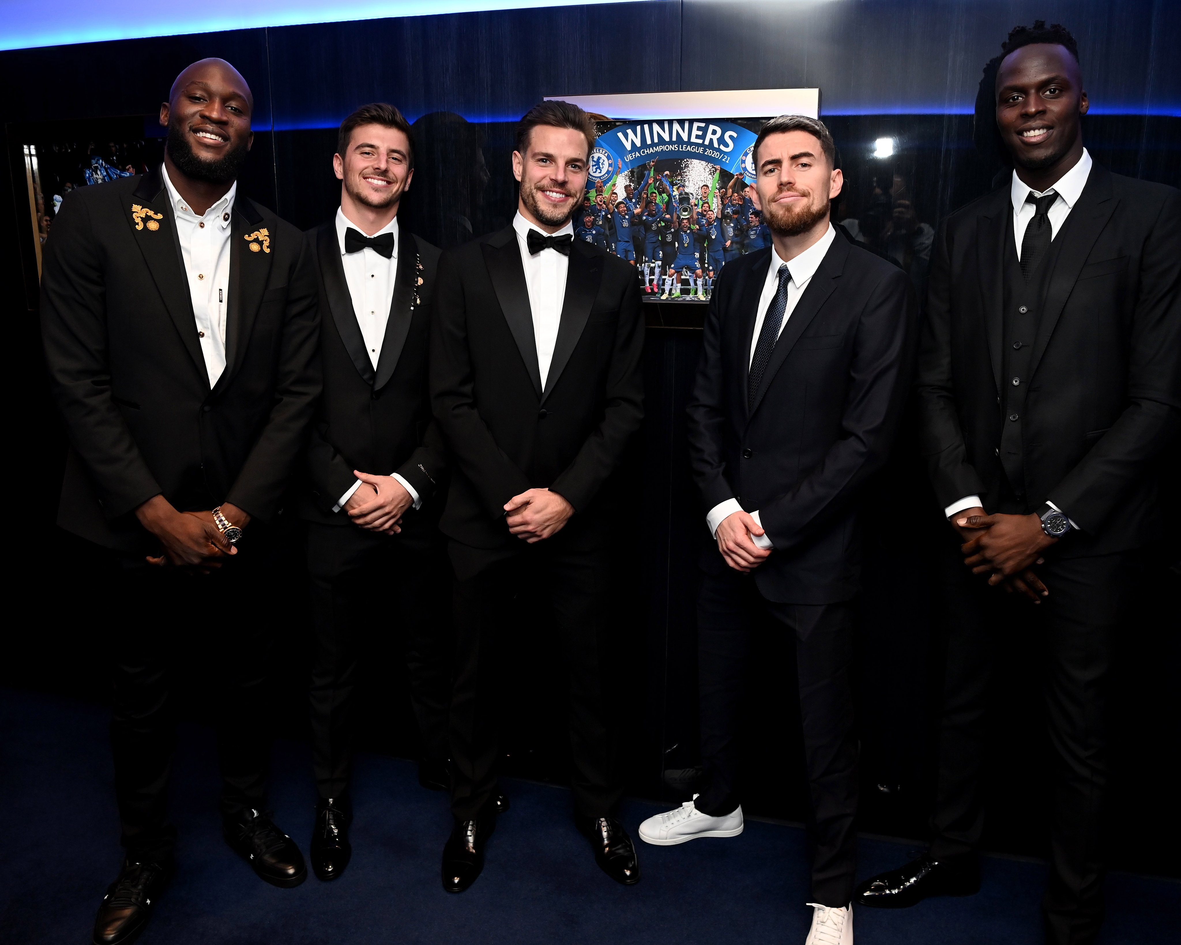 若日尼奥和门将门迪并排而立,众人在切尔西夺得欧冠冠军的照片前合影