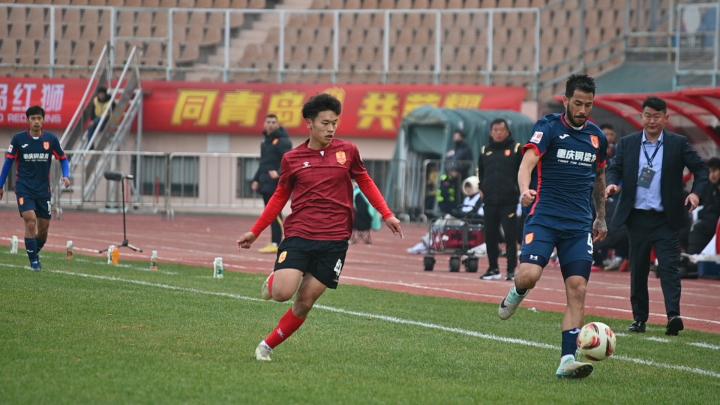 后第10分钟,青岛红狮队藏哈尔·拜沙提汗下底传中,吴俊豪抢到落点打高